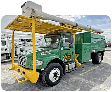 Crown Arborists green chip truck with boom and aerial lift
